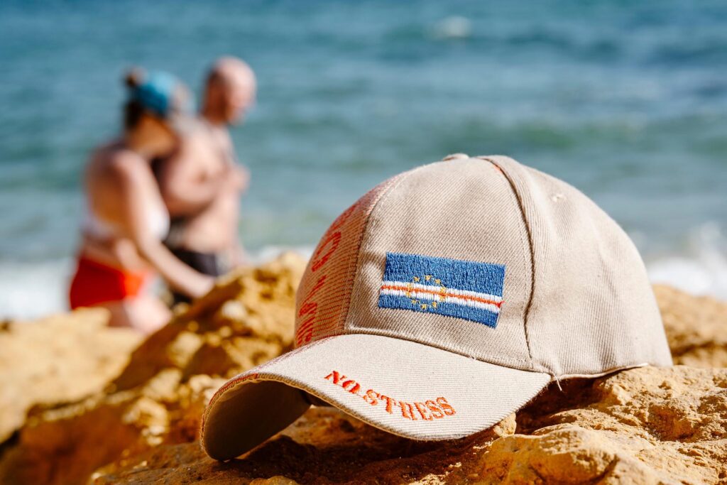 Baseball Cap with Ocean and blurry People in the background of São Rafael's Beach in Albufeira, Portugal; Shutterstock ID 2522892891; purchase_order: -; job: -; client: -; other: -
